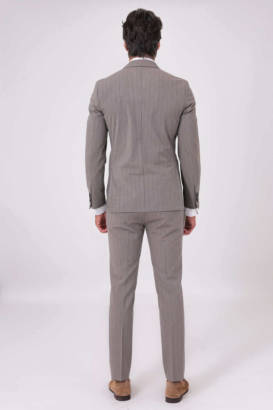 Abito doppiopetto beige indossato con giacca e pantaloni coordinati, vista frontale