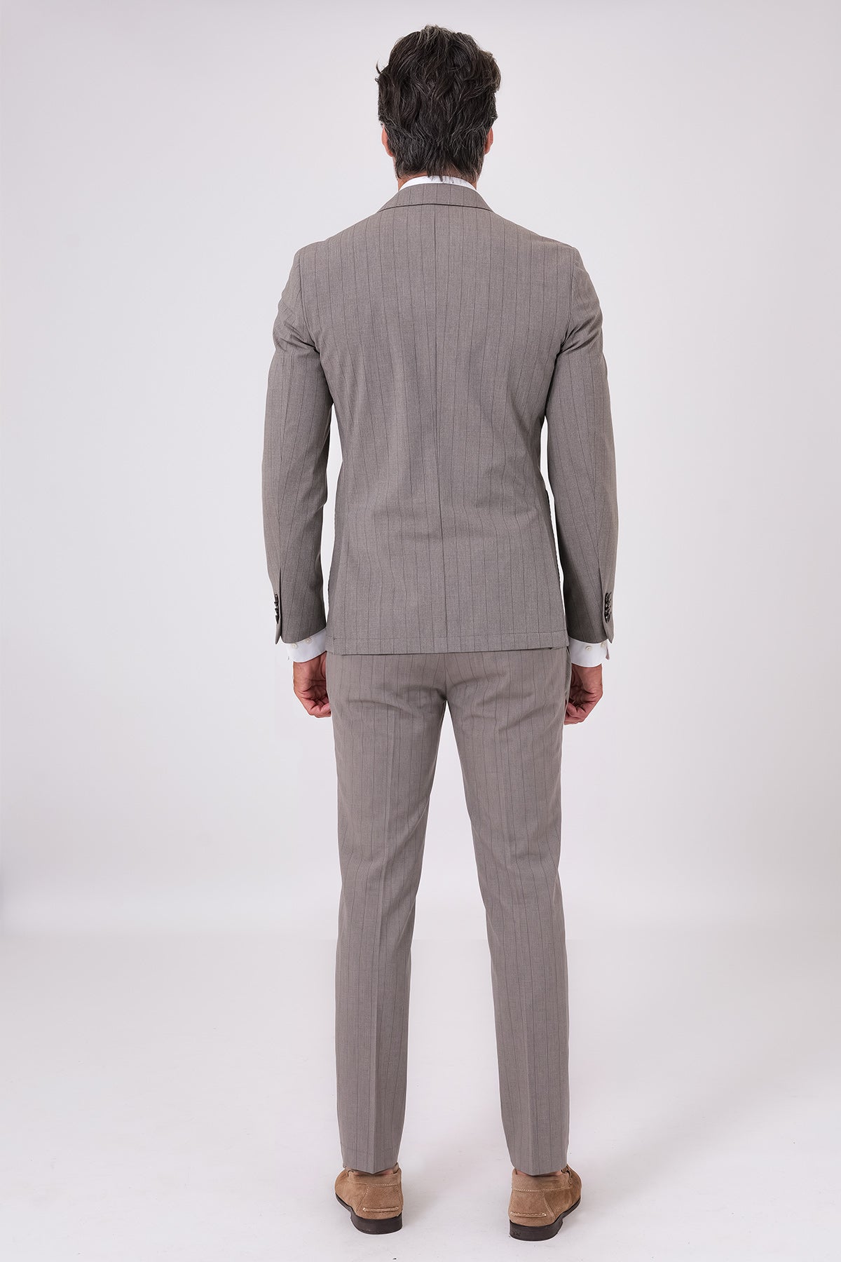 Vista posteriore dell'abito beige con giacca e pantaloni coordinati indossati