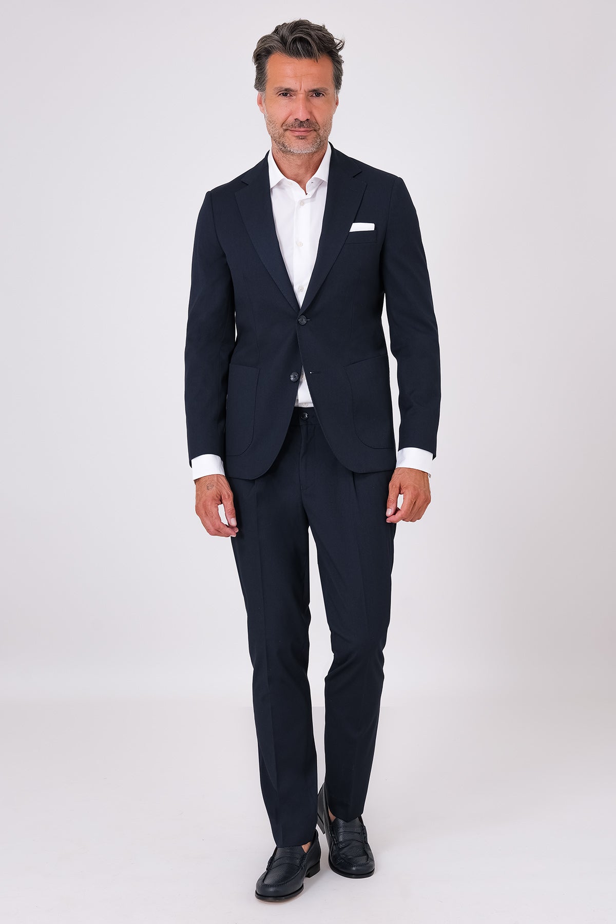 Navy blue suit on a model, front view with patch-pocket jacket and matching trousers