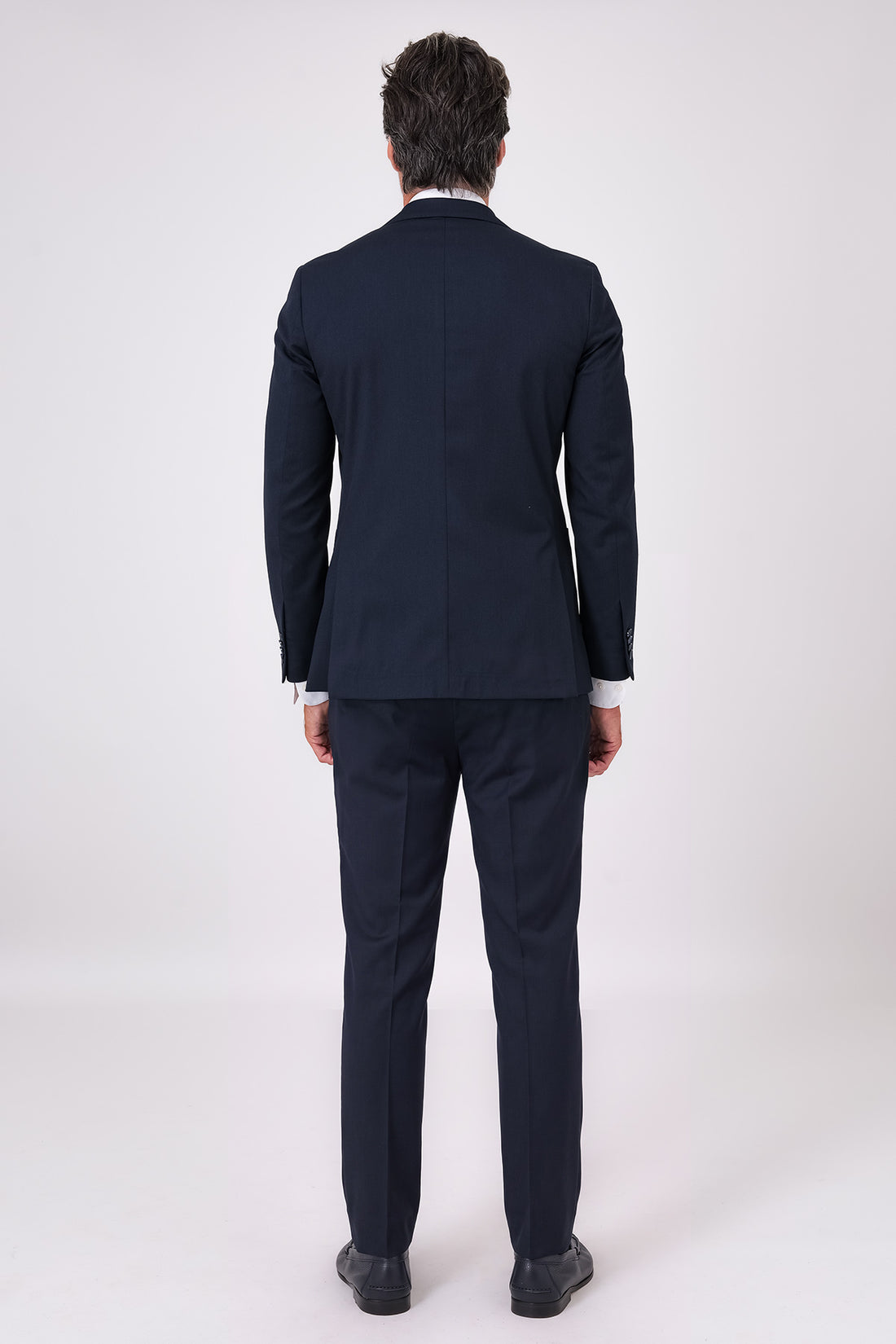 Abito blu navy indossato, vista frontale con giacca a tasche a toppa e pantaloni coordinati