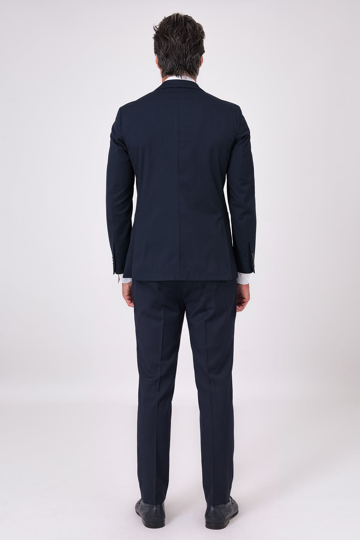 Rear view of the navy blue suit on a model with matching jacket and trousers