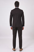 Rear view of a dark brown suit on a model, featuring a matching jacket and trousers