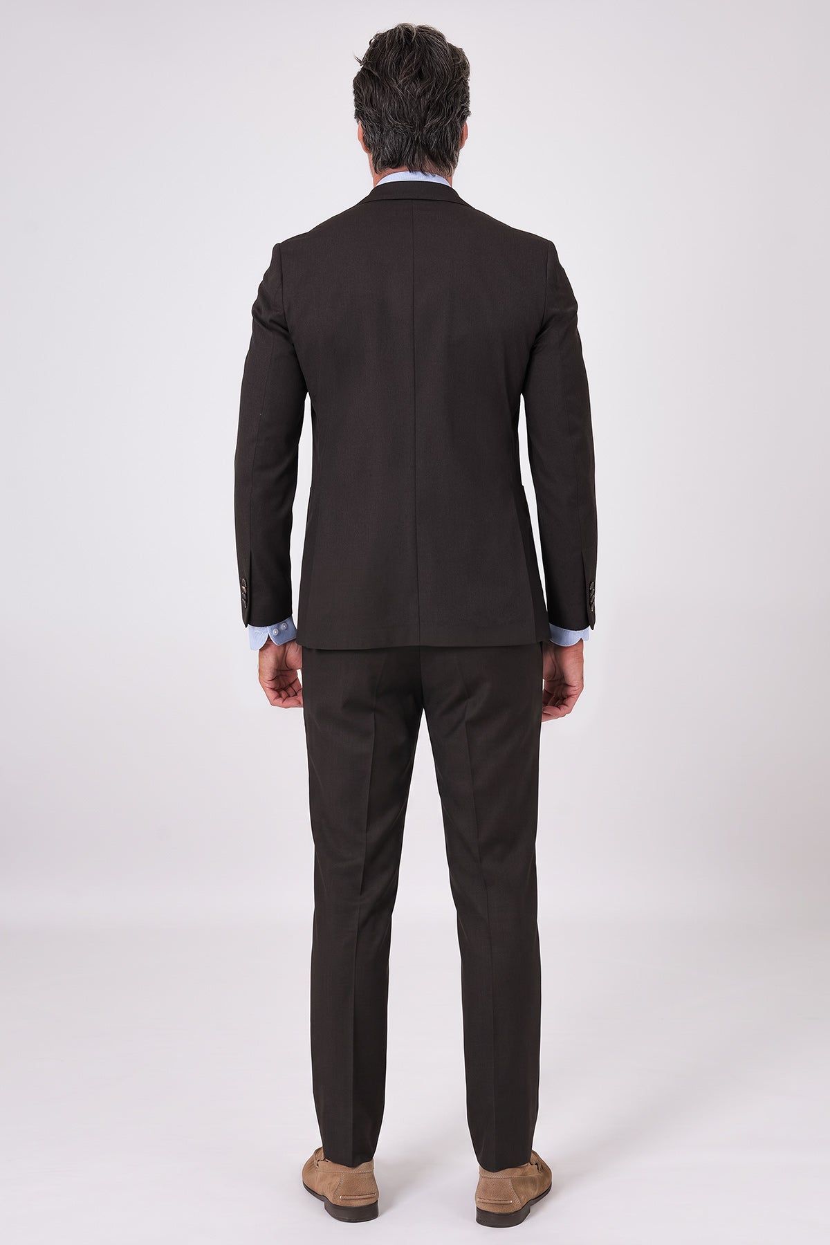 Rear view of a dark brown suit on a model, featuring a matching jacket and trousers