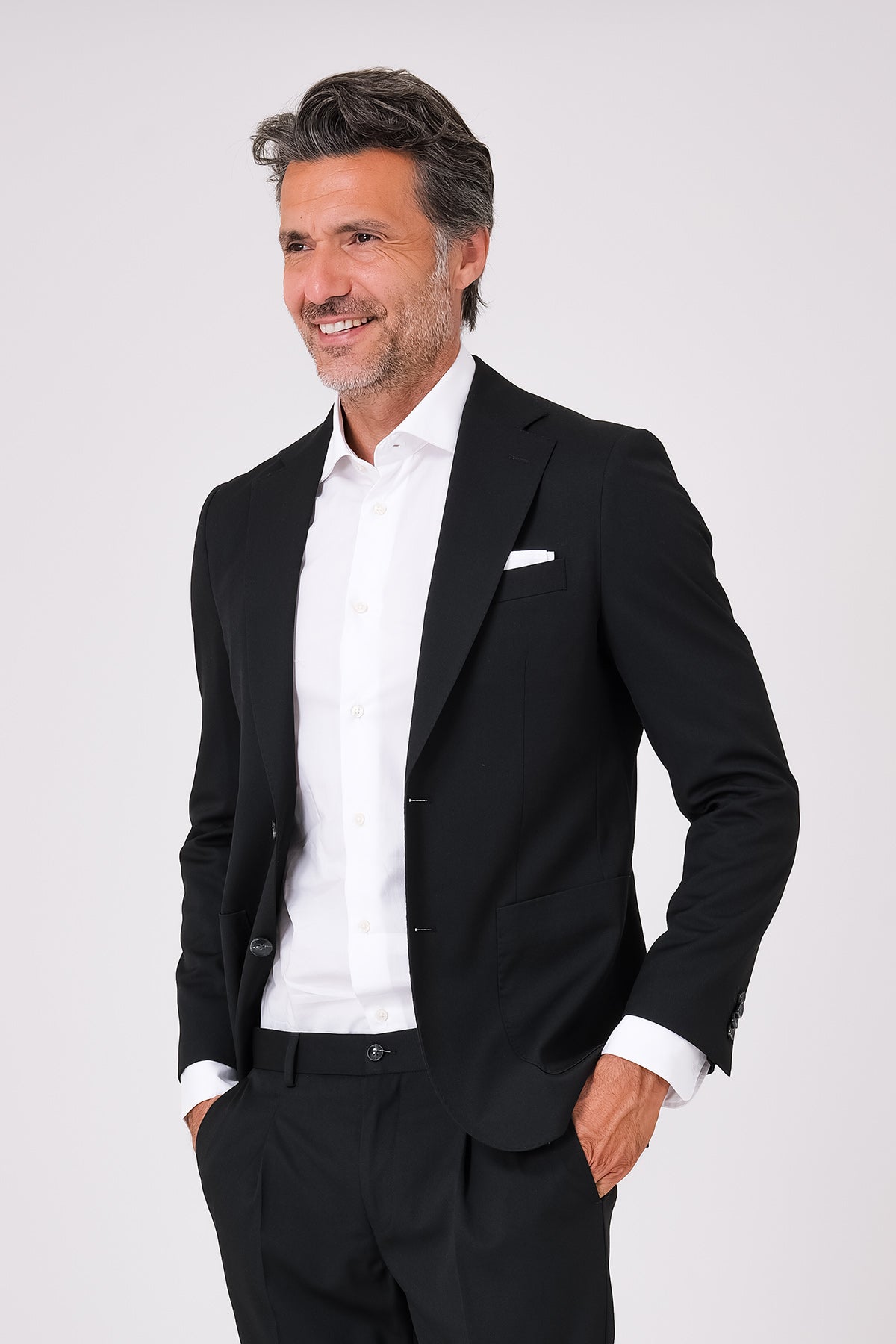 Black suit with two-button jacket and patch pockets on a model, front view