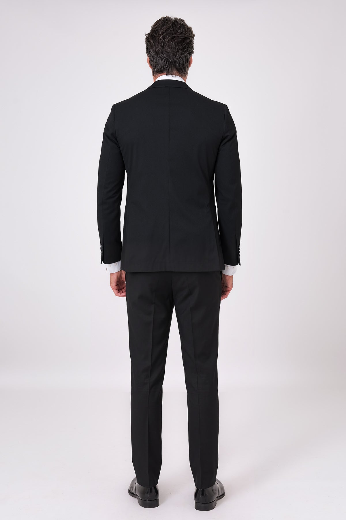 Rear view of the black two-piece suit with jacket and trousers on a model
