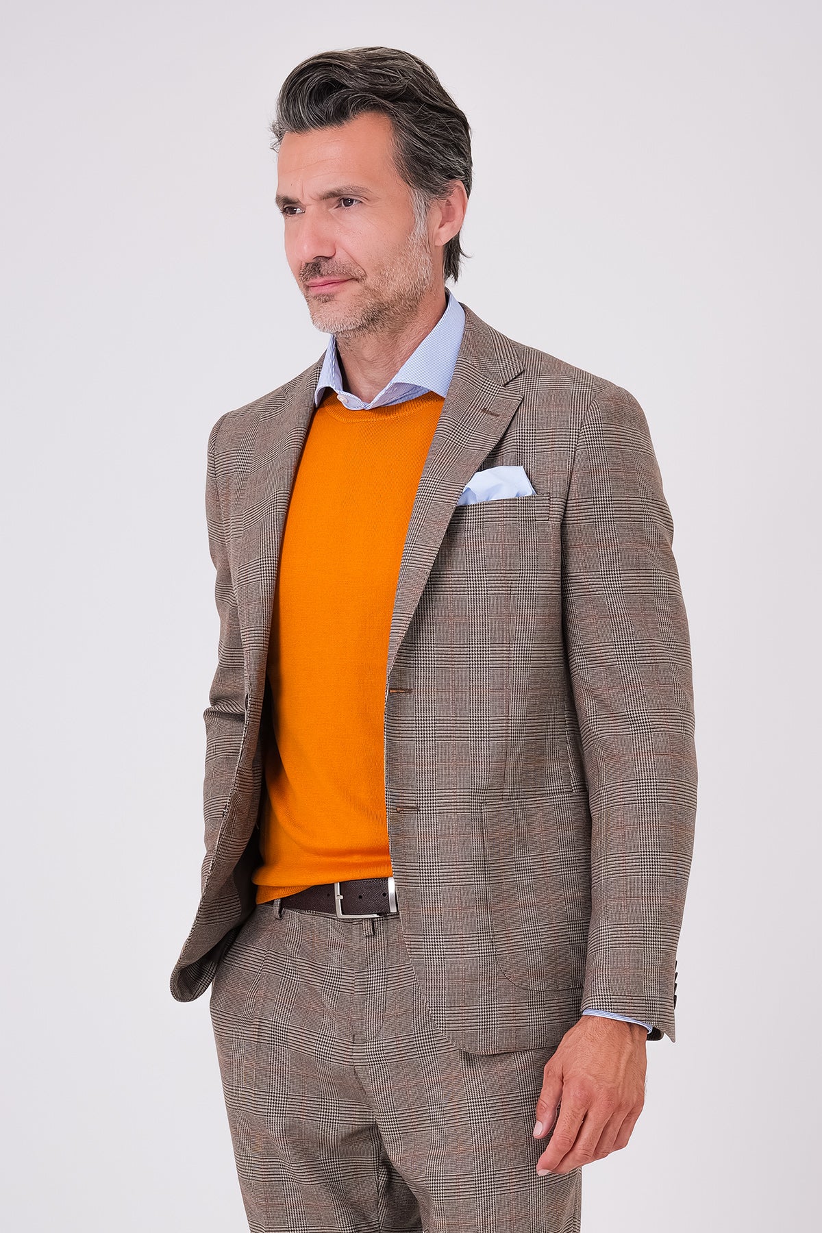 Vista frontale dell'abito beige a due bottoni con giacca a quadri e tasche a toppa indossato