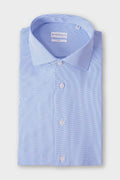 Folded light blue shirt with a spread collar and small, spaced geometric motifs