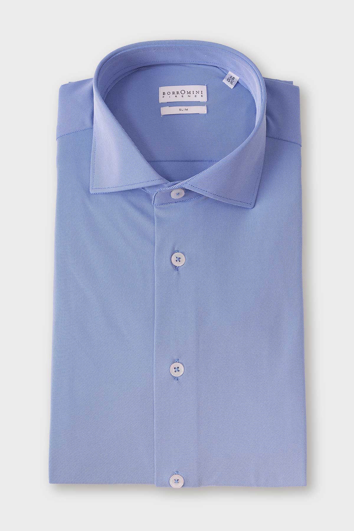 Folded shirt in denim blue with a spread collar and a dense geometric micro-pattern