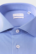 Close-up of the spread collar and dense geometric micro-pattern on the denim-blue shirt