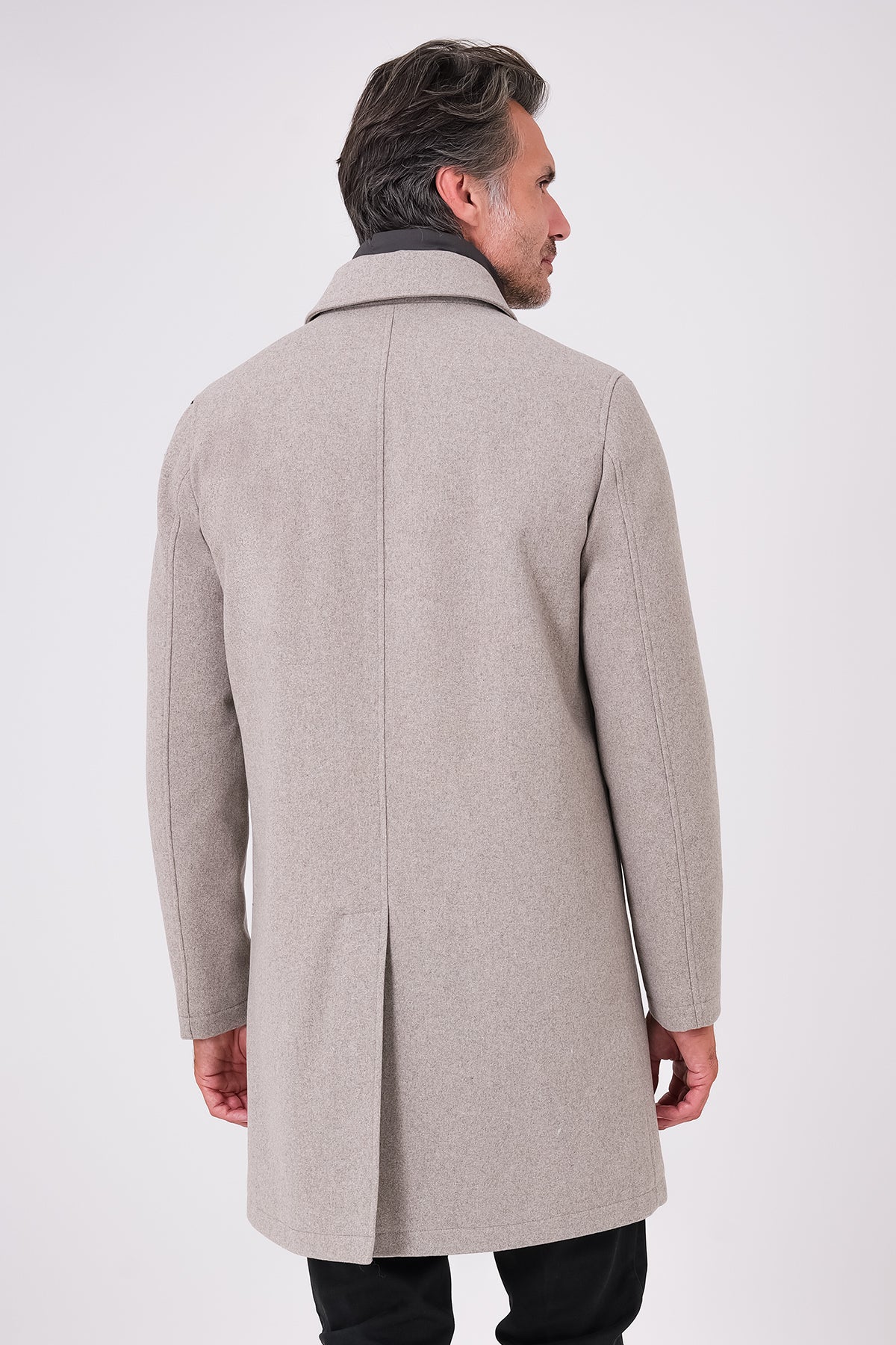 Vista posteriore del cappotto beige con spacco centrale indossato