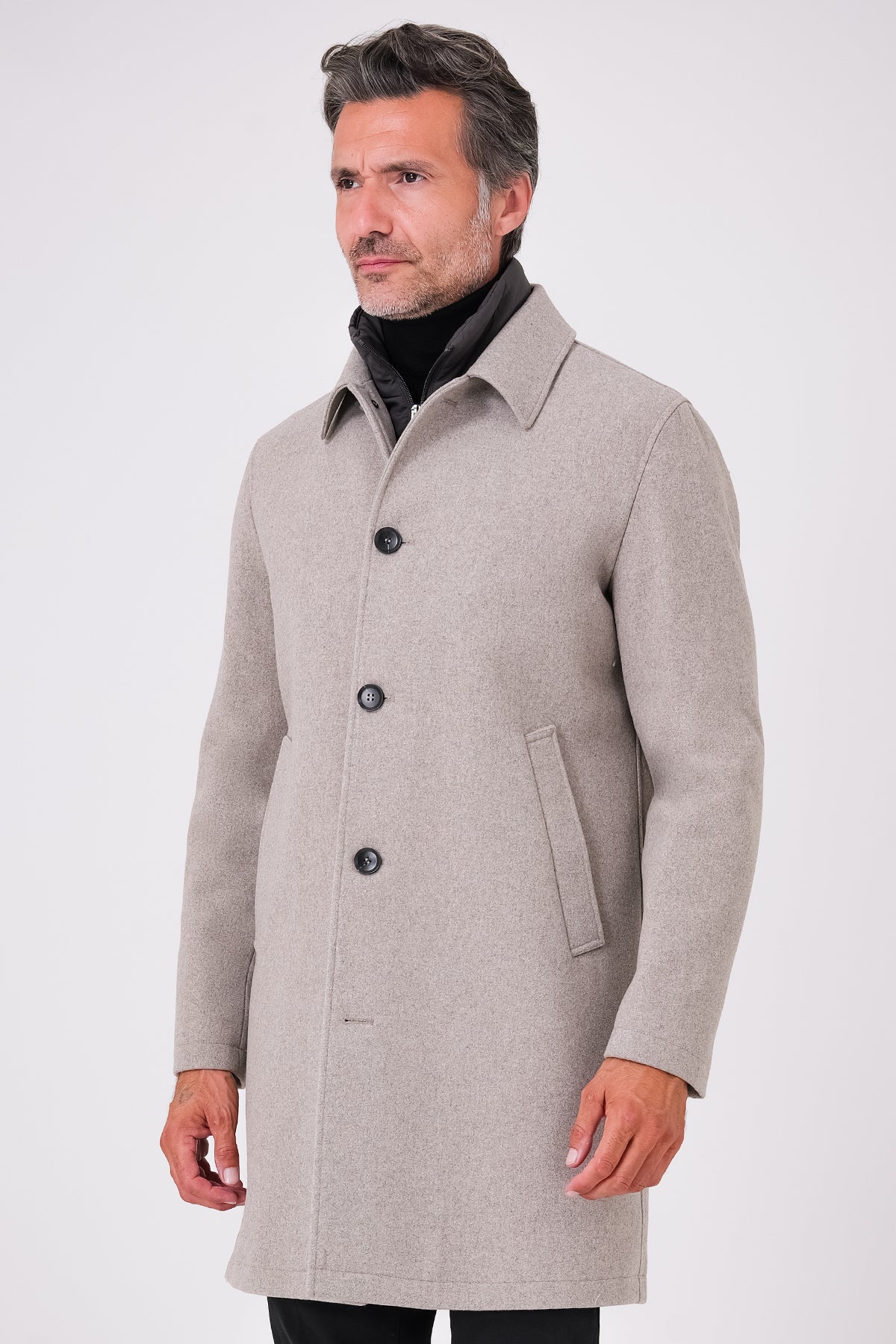 Vista frontale del cappotto beige con bottoni indossato
