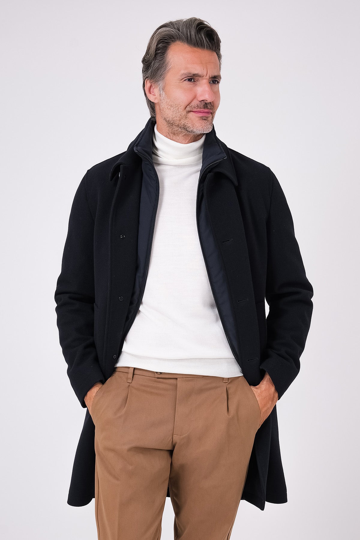 Cappotto blu navy con pettorina interna aperto sul davanti, indossato
