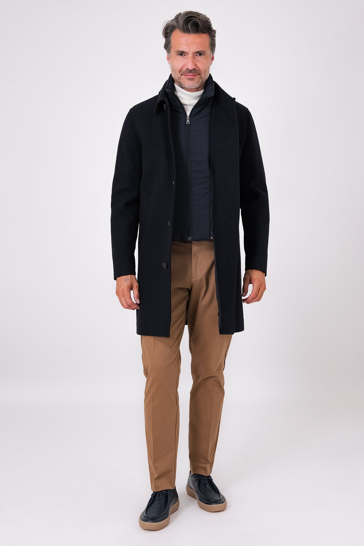 Cappotto blu navy con pettorina interna con zip, indossato dal modello in vista frontale