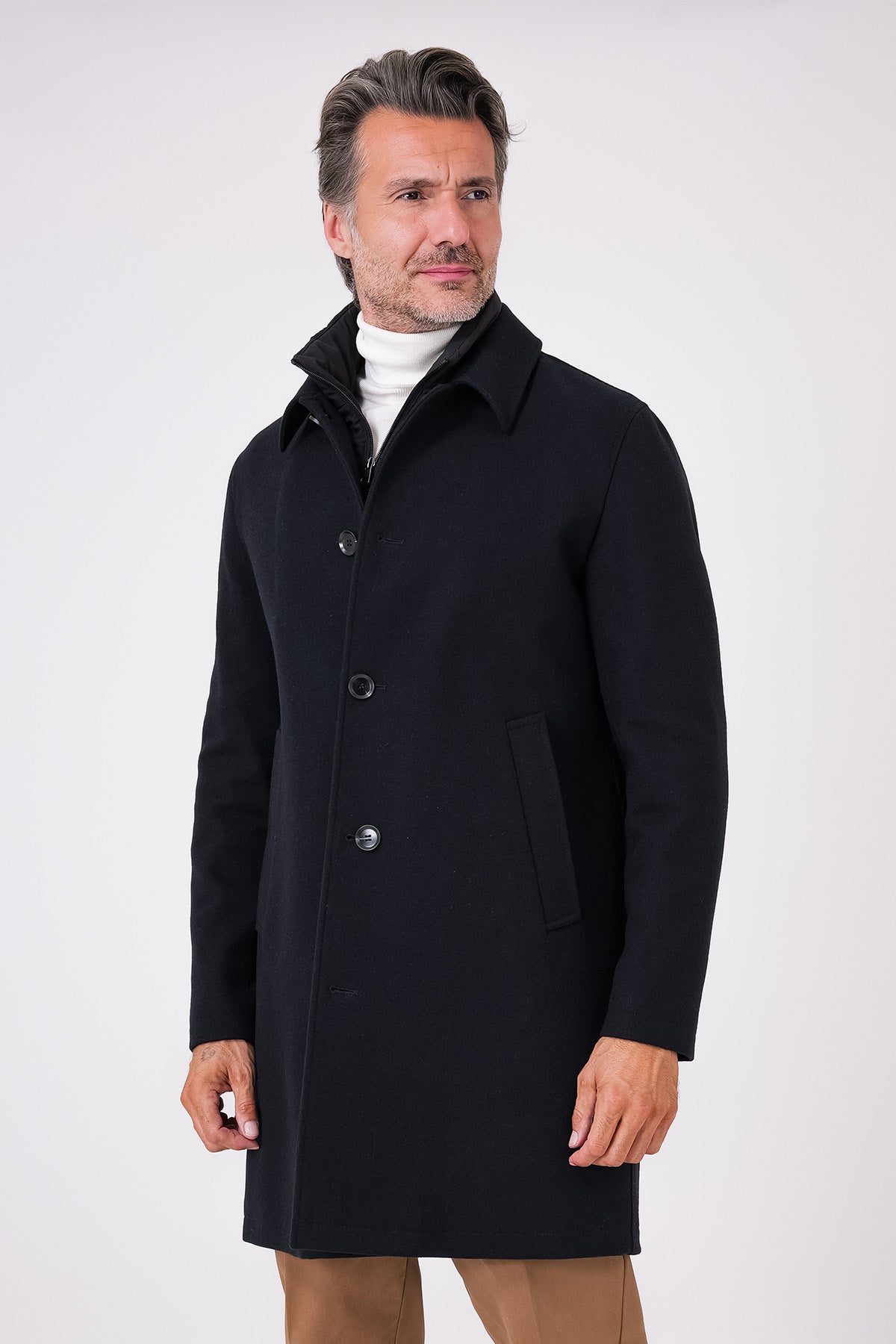 Cappotto nero con pettorina e abbottonatura frontale indossato da un modello