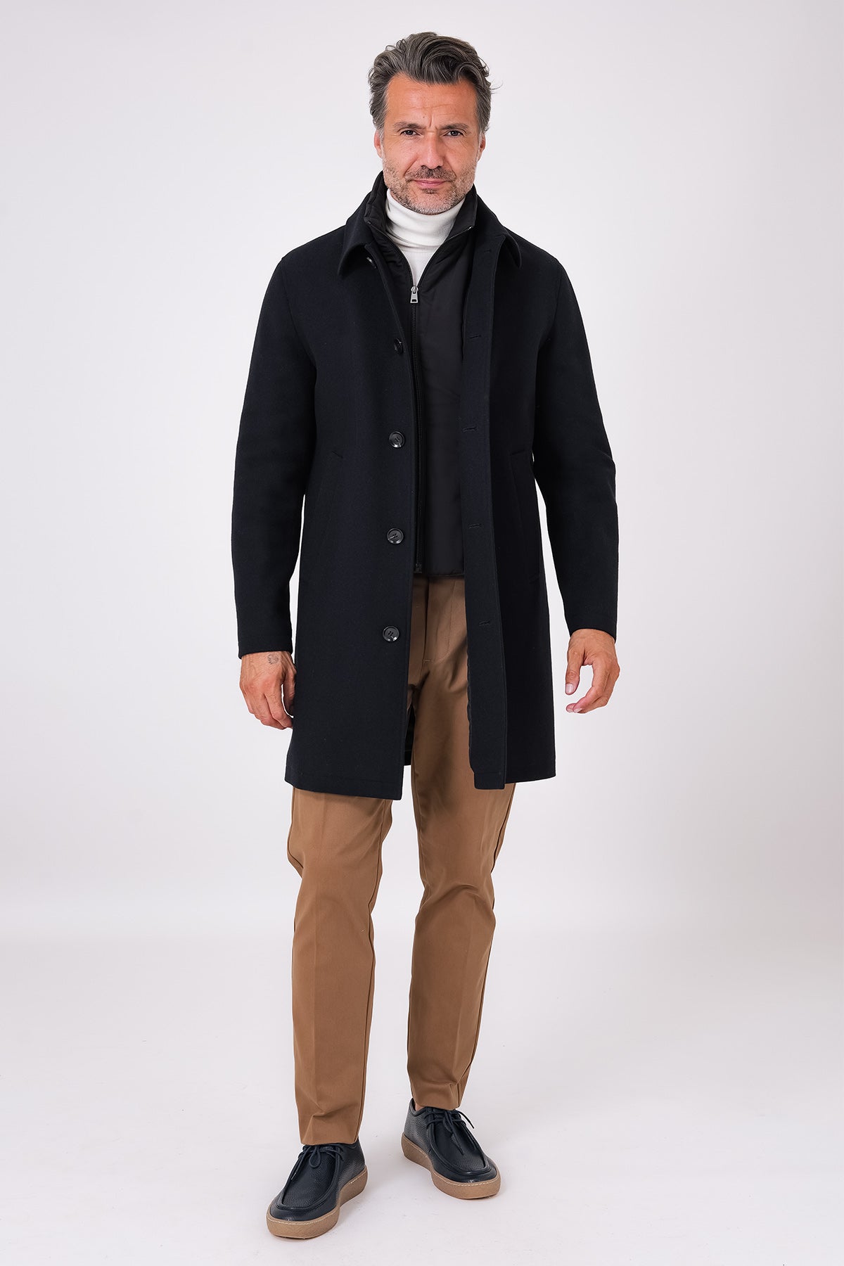 Cappotto nero con pettorina e chiusura a bottoni indossato, vista frontale