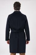 Vista posteriore del cappotto blu navy indossato, con cintura in vita e maniche raglan