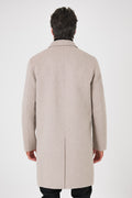Rear view of the beige coat on a model with a centre vent