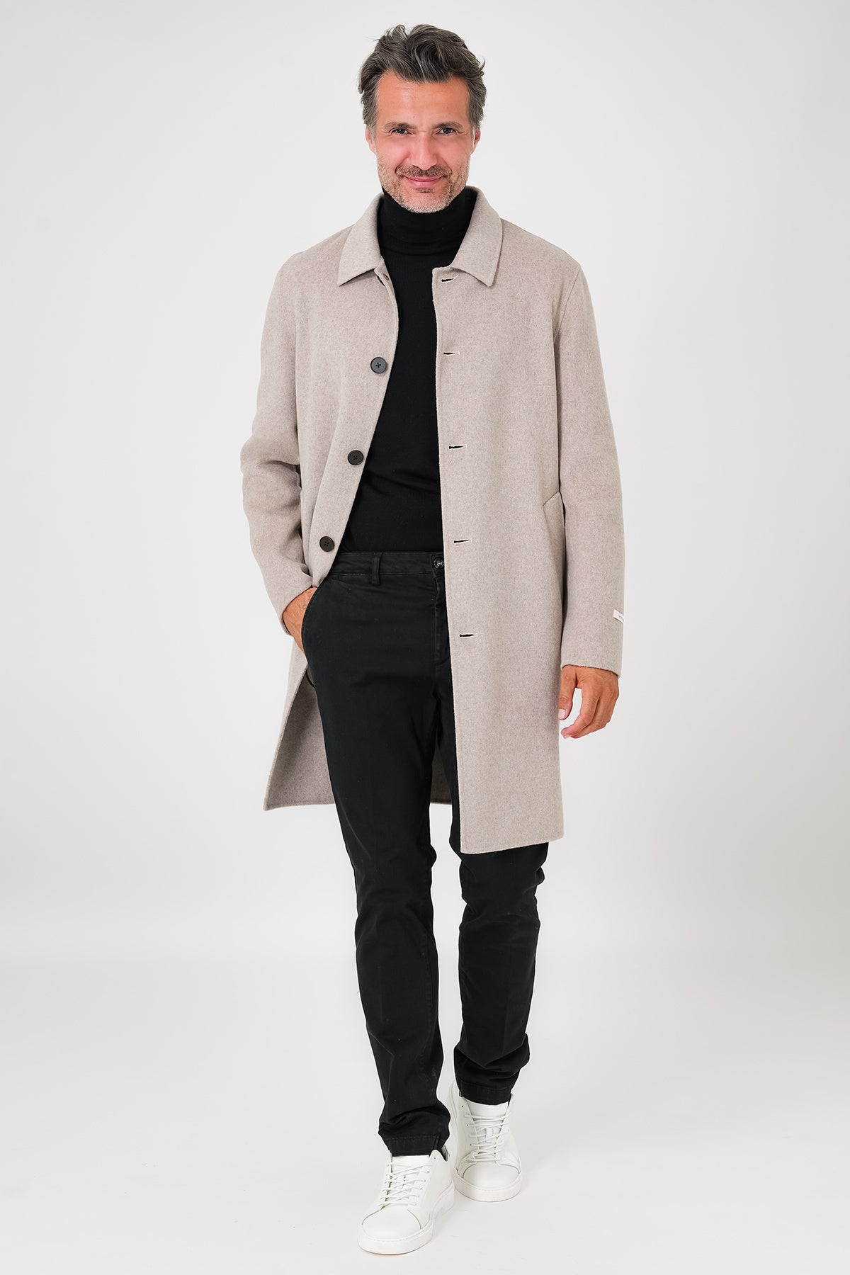 Front view of a beige coat with a shirt collar and visible buttons on a model