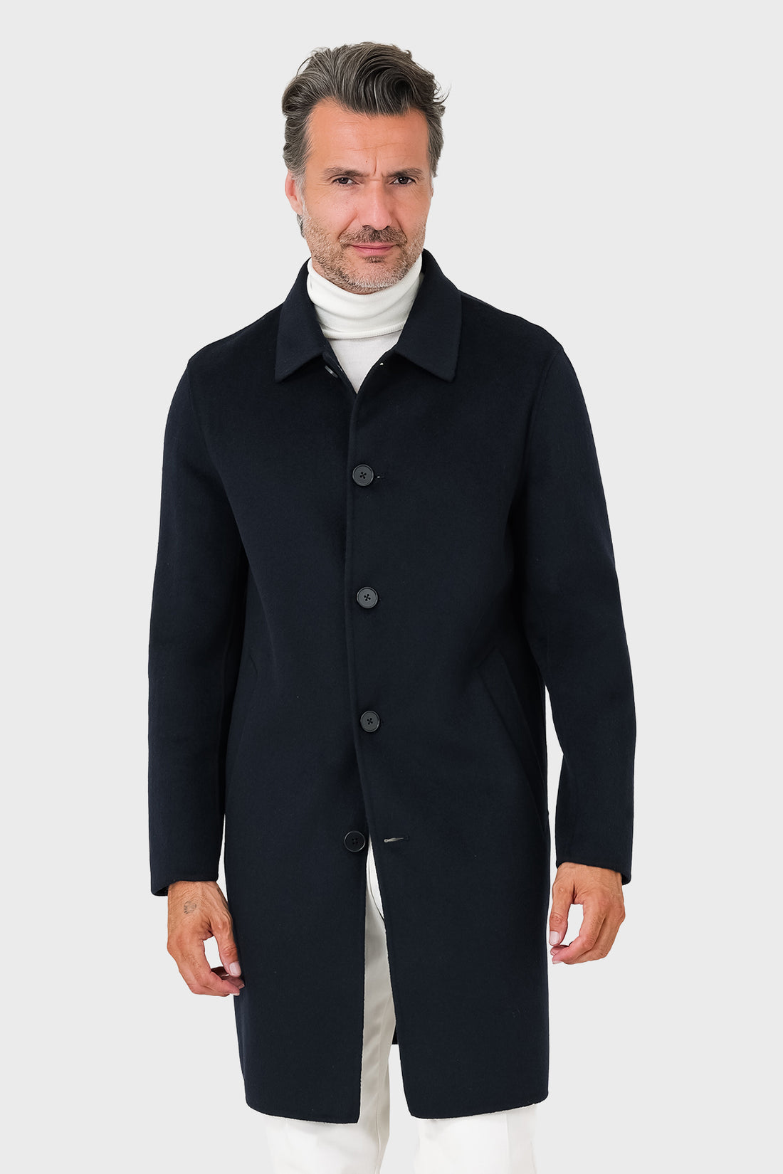 Vista frontale del cappotto blu navy con collo a camicia e bottoni a vista, indossato