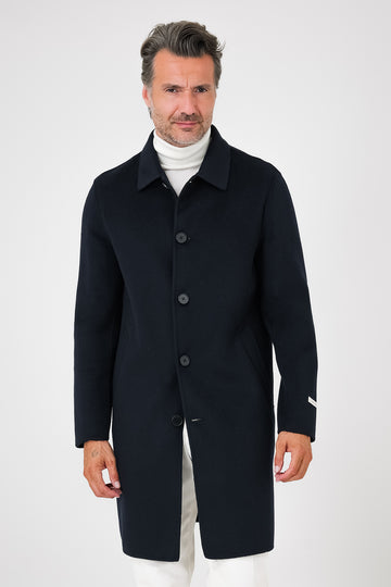 Front view of navy blue coat with shirt collar and visible buttons on a model