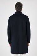 Rear view of the navy blue double-faced coat on a model, with a centre vent