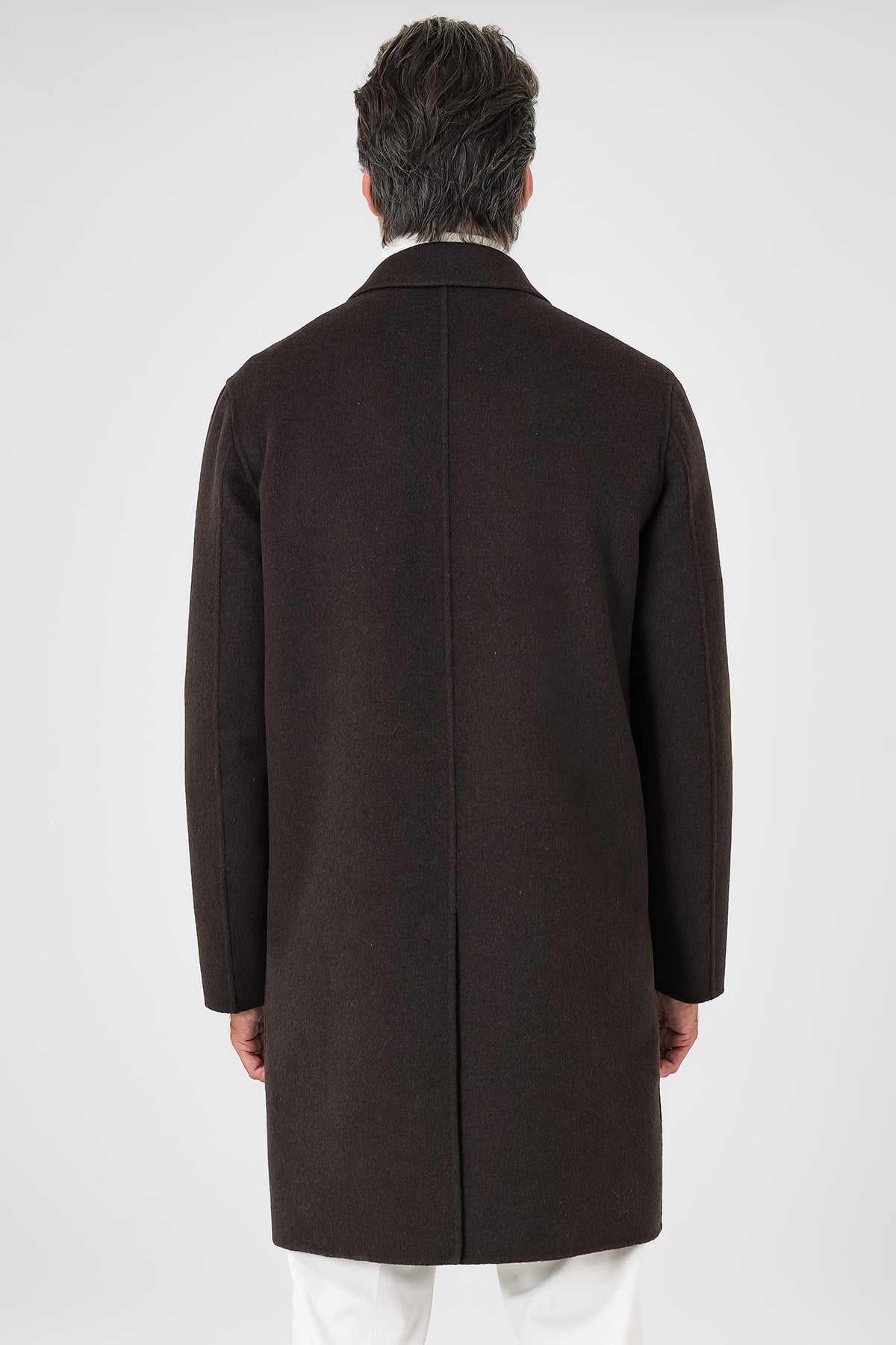 Back view of the dark brown double-faced coat on a model, with central seam and vent