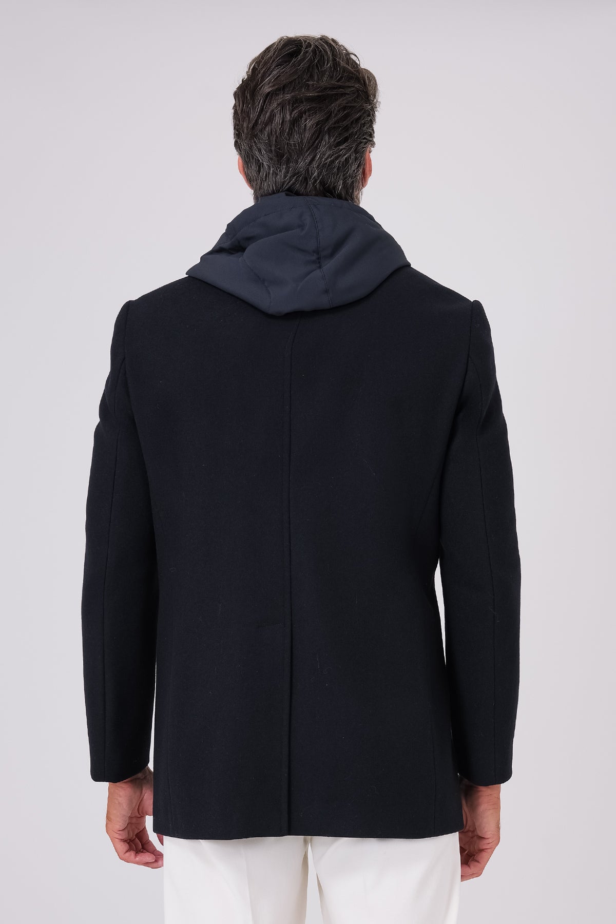 Vista posteriore del cappotto lupo di mare blu navy indossato con cappuccio sulle spalle
