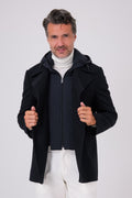 Vista frontale del cappotto lupo di mare blu navy indossato, aperto sulla pettorina interna con cappuccio