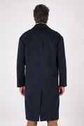 Rear view of navy blue oversized coat with dropped armholes and centre vent on a model