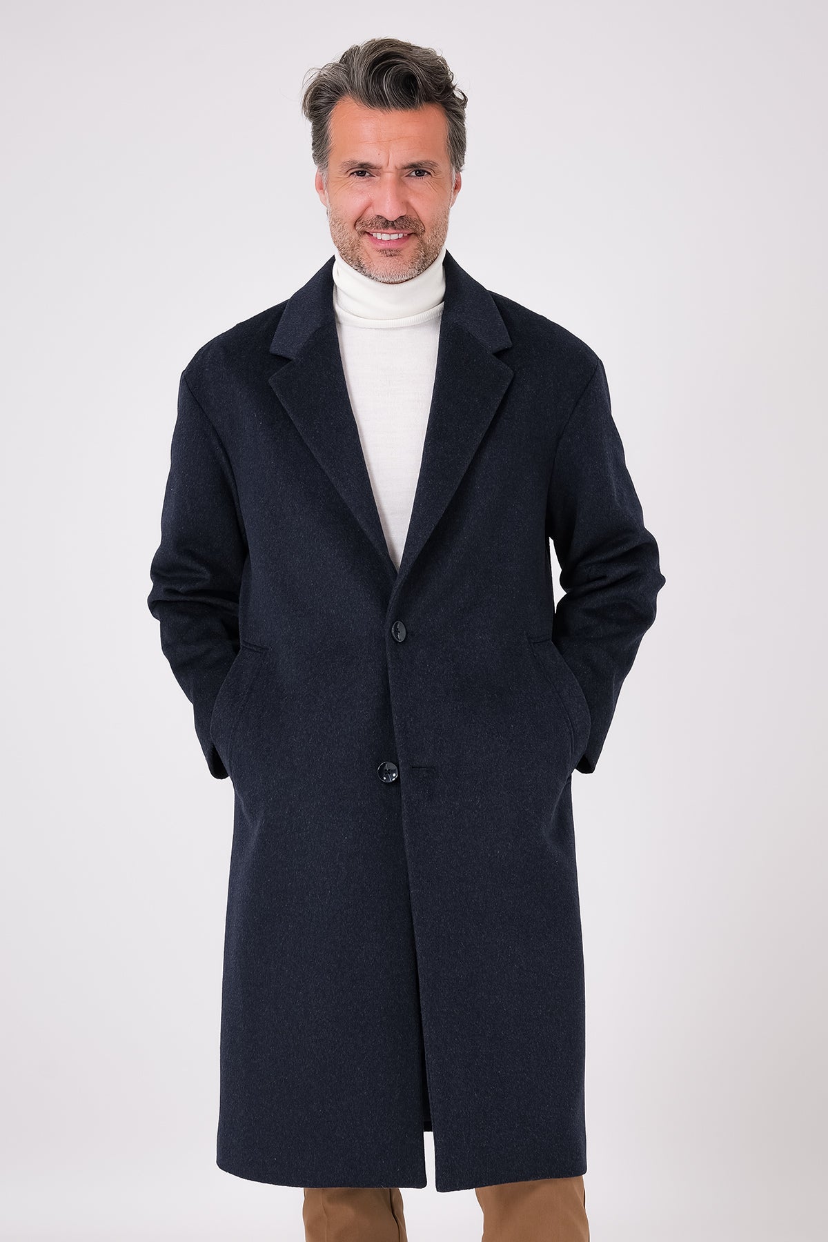 Front view of an oversized single-breasted navy blue coat with lapel collar on a model