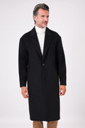 Black single-breasted oversized coat with dropped shoulders on a model, front view