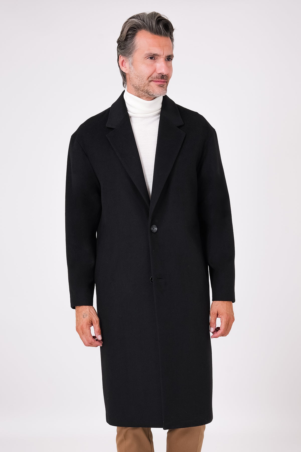 Black single-breasted oversized coat with dropped shoulders on a model, front view