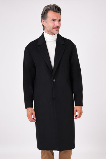Black single-breasted oversized coat with dropped shoulders on a model, front view