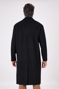Back view of the black oversized coat with dropped armholes and centre vent on a model