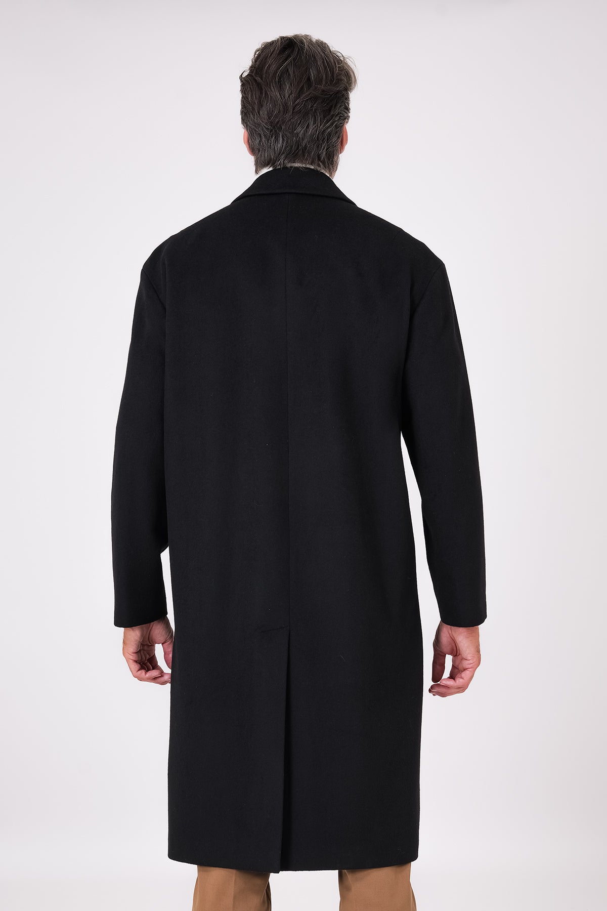 Back view of the black oversized coat with dropped armholes and centre vent on a model