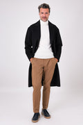Front view of an oversized black coat with lapels worn open on a model