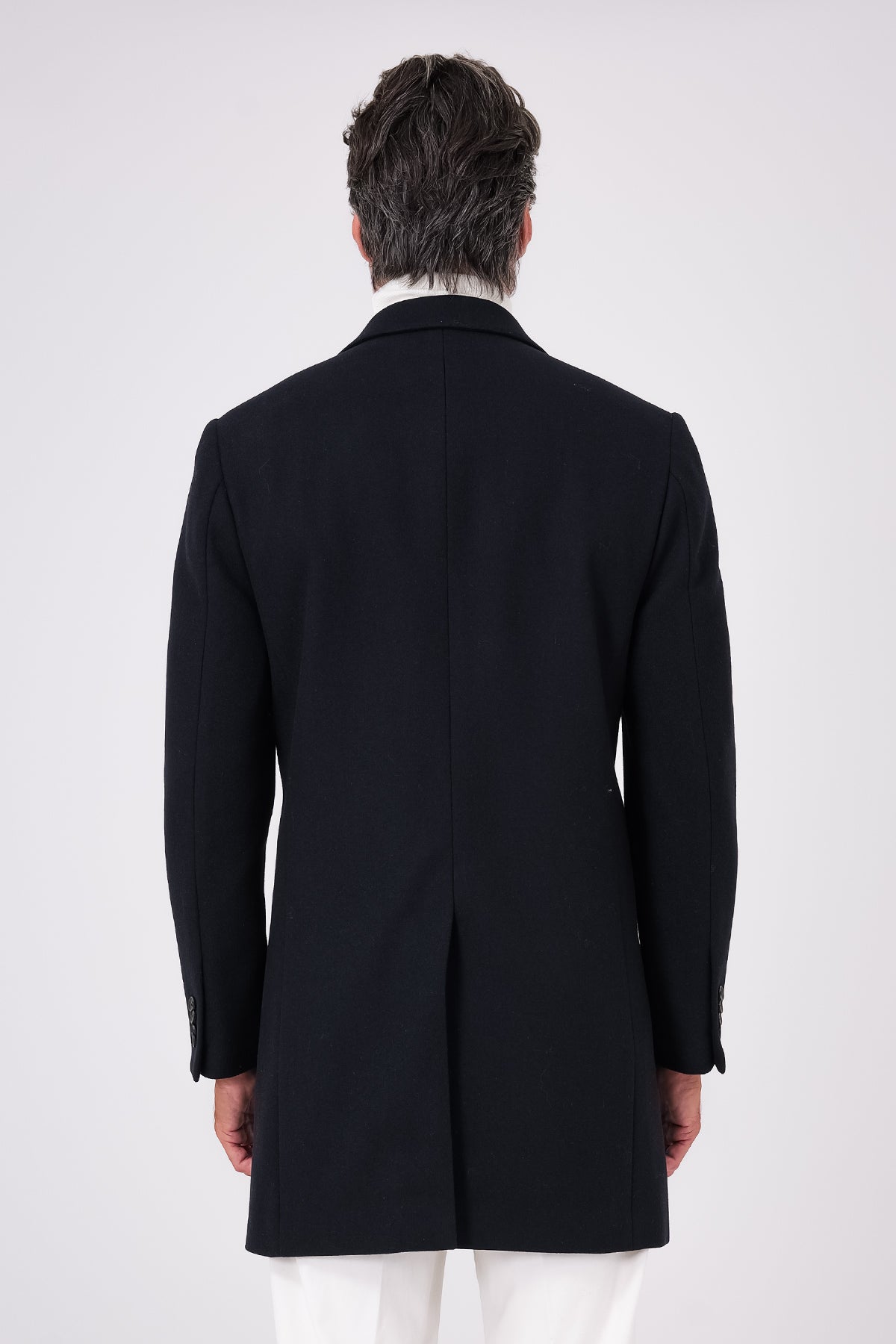 Vista posteriore del cappotto in misto lana blu navy indossato con spacco centrale