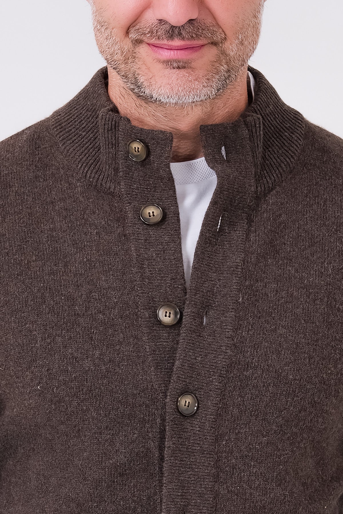 Dettaglio del collo alto a costine e dell'abbottonatura del cardigan marrone indossato