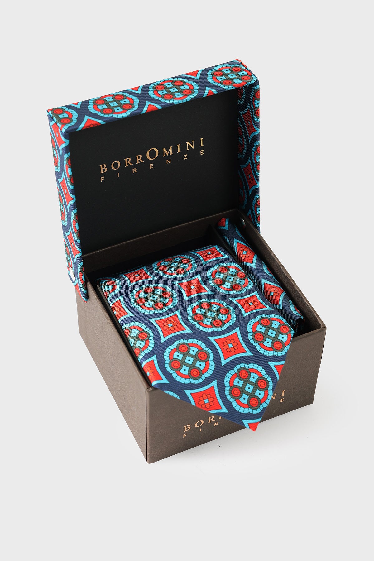 Cravatta e pochette in seta multicolore a medaglioni disposte nella scatola aperta
