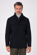 Vista frontale di un giaccone blu navy indossato, con collo alto e tasche con patta sul petto