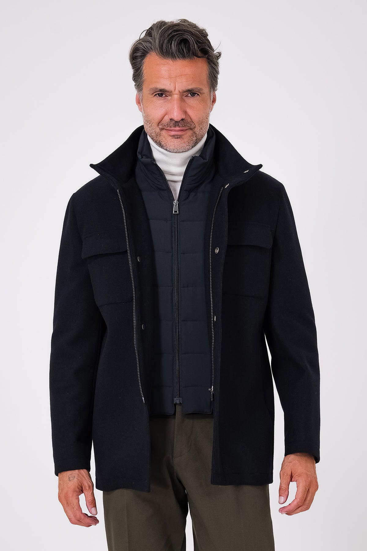 Vista frontale del giaccone blu navy indossato, con pettorina tecnica trapuntata e collo rialzato