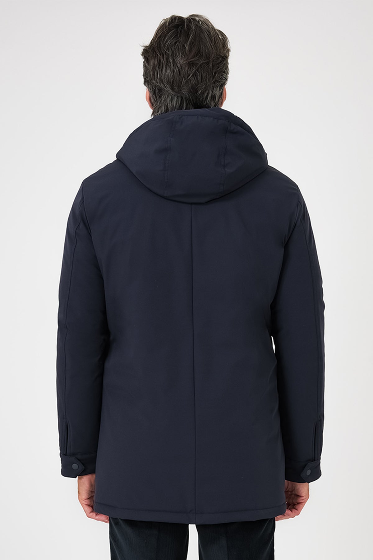 Vista posteriore del giaccone tecnico con cappuccio blu navy indossato