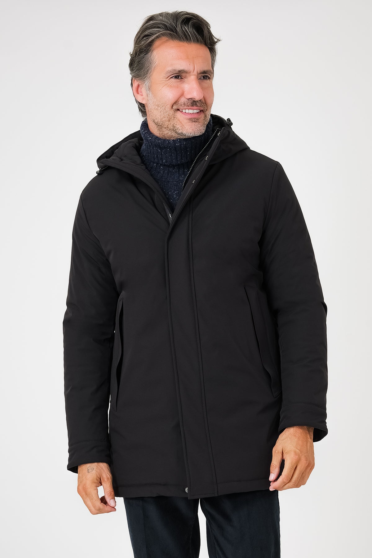 Giaccone tecnico nero con cappuccio indossato da uomo, vista frontale