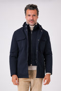 Vista frontale del giaccone tecnico blu navy con pettorina interna e tasche sul petto indossato
