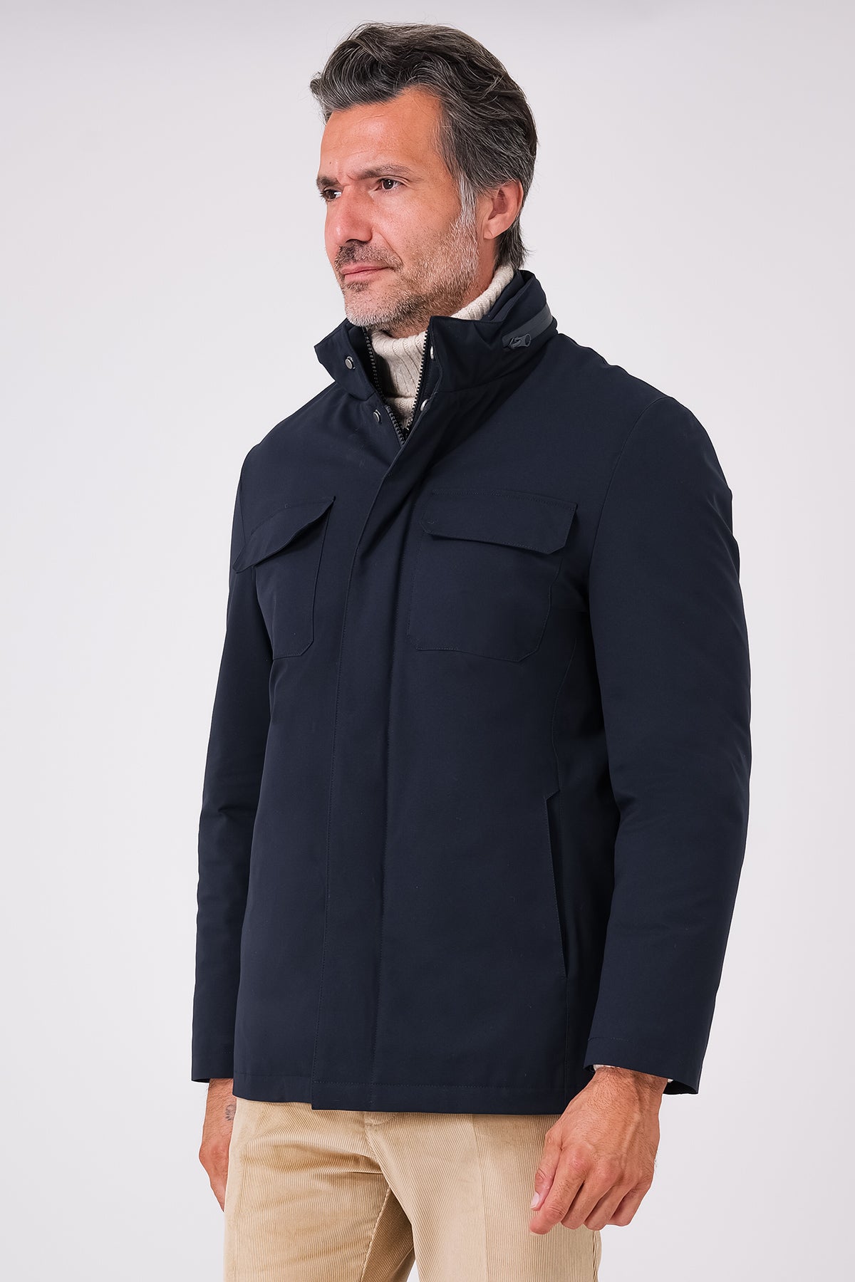 Giaccone tecnico blu navy indossato, vista frontale con tasche sul petto e collo alto