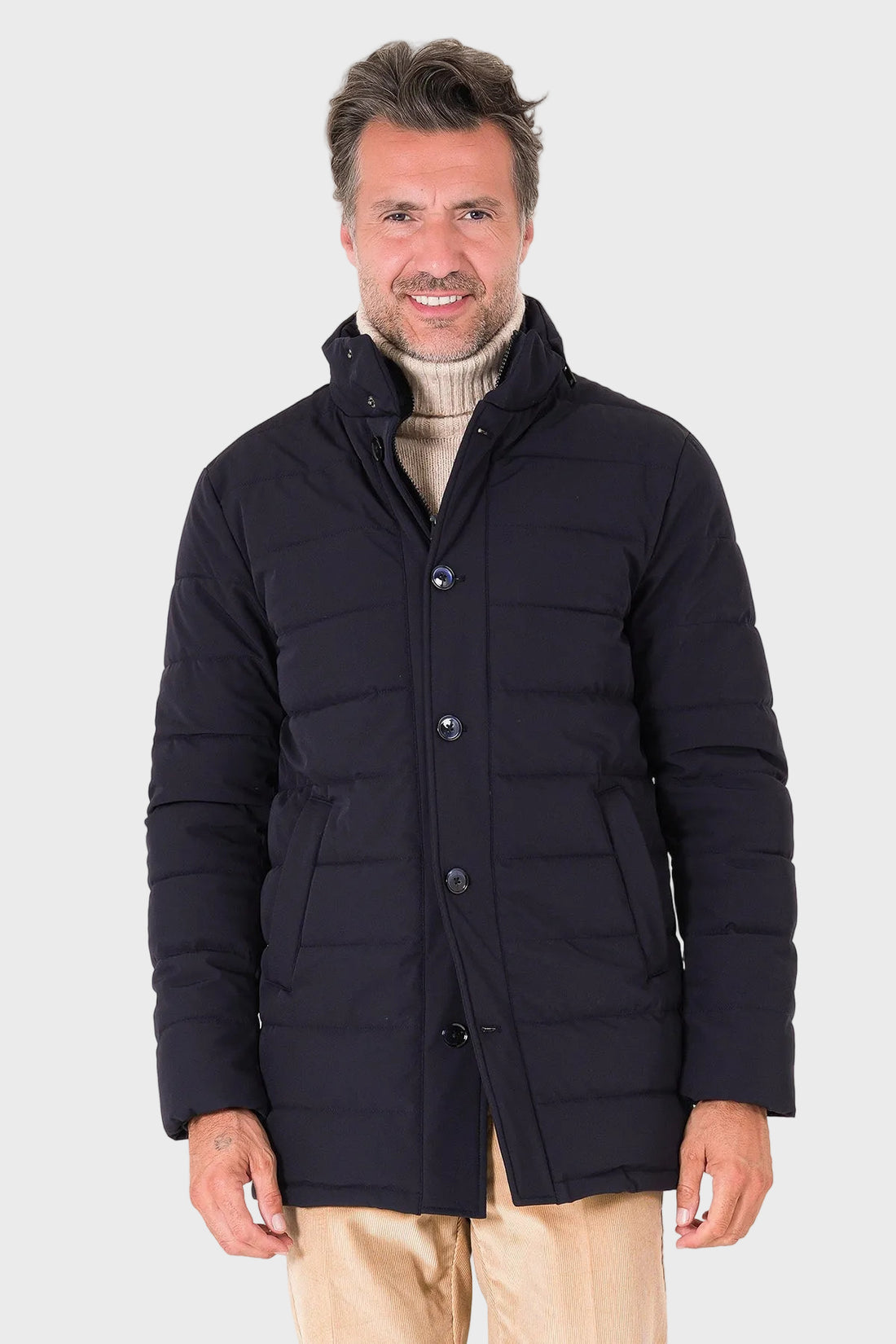 Vista frontale del giaccone tecnico trapuntato blu navy indossato con collo alto e chiusura a bottoni