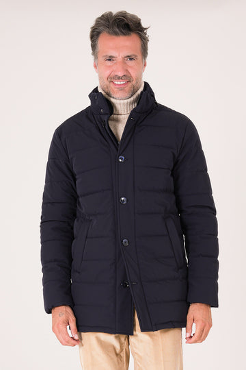 Vista frontale del giaccone tecnico trapuntato blu navy indossato con collo alto e chiusura a bottoni