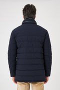 Vista posteriore del giaccone tecnico trapuntato blu navy indossato