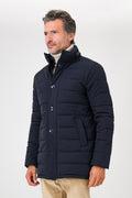 Giaccone trapuntato blu navy indossato, con collo alto e tasche inclinate visto dal davanti