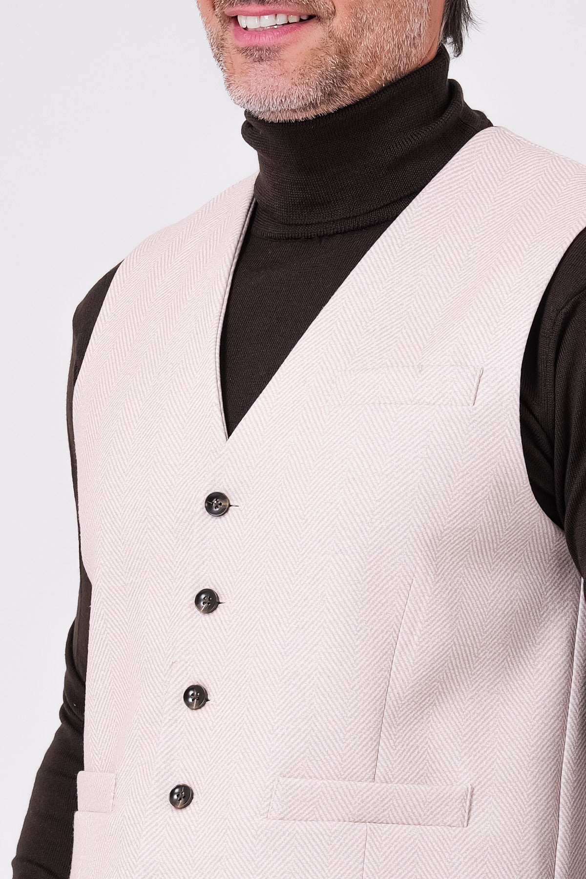Front detail of beige herringbone waistcoat with V-neck and buttons